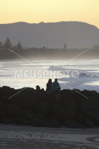 Couple watching sunset at sea in Byron Bay - MeusPhoto